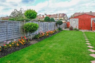 Residential garden with red shed and wooden fencing